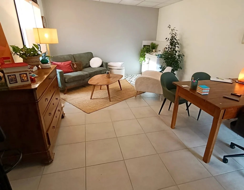 Intérieur du cabinet de psychologie à Aubenas : un espace de consultation confortable et apaisant avec canapé et fauteuils.